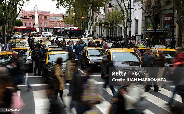Cabs block Mayo avenue as taxi drivers protest against Uber in Buenos Aires on April 12, 2016. Uber started operating in Buenos Aires Tuesday without...