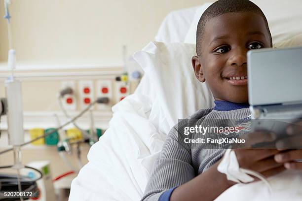 boy playing video games in a hospital - bärbar dvd spelare bildbanksfoton och bilder