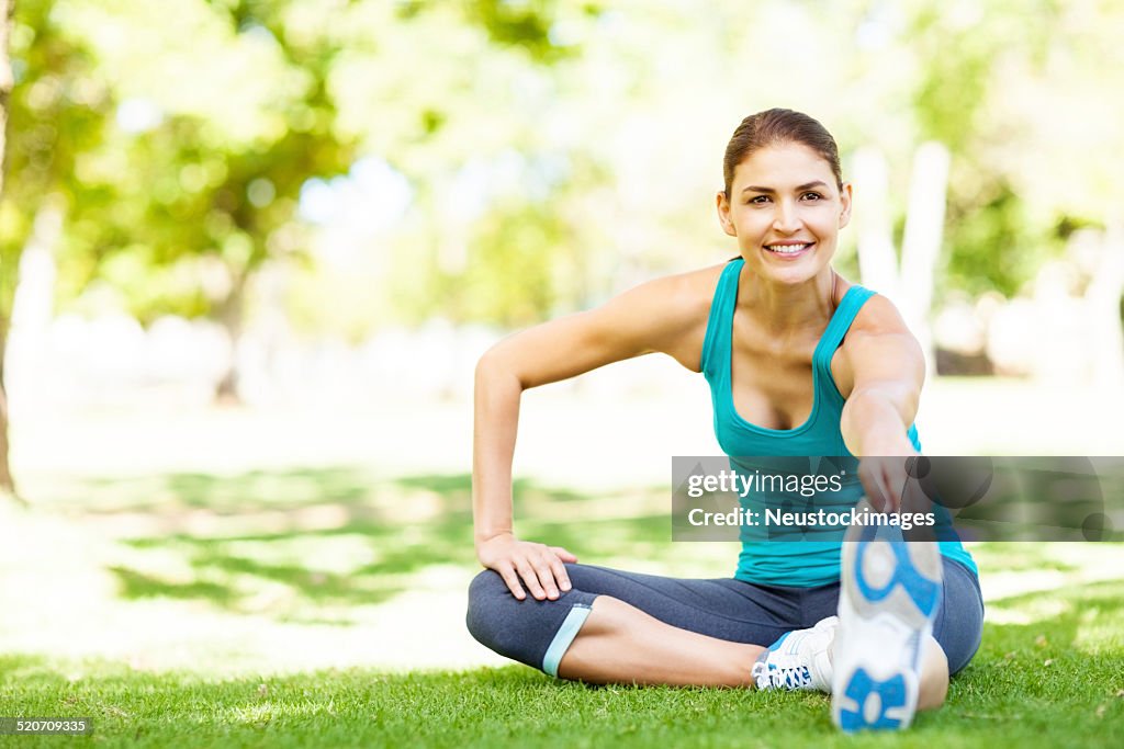 Deportivo mujer haciendo ejercicios de estiramiento en el parque