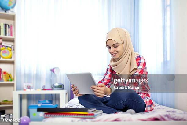 teenage muslim girl using tablet computer - beautiful arab girl stock pictures, royalty-free photos & images