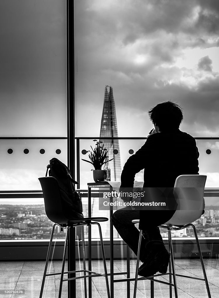 Rear view of Young Man looking out over London Skyline