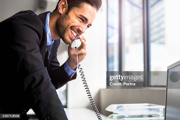 businessman using landline phone in office - landline phone stock pictures, royalty-free photos & images