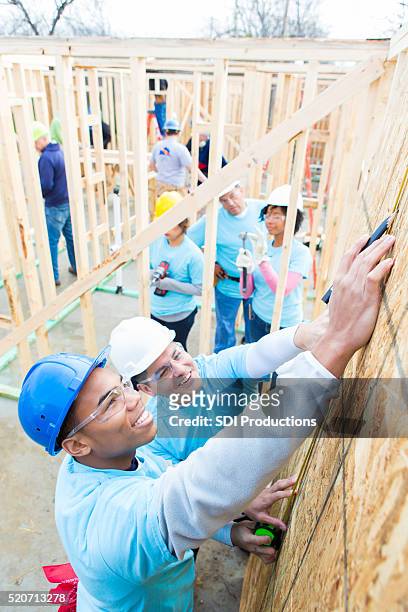 team of volunteers work together to build home - volunteer building stock pictures, royalty-free photos & images