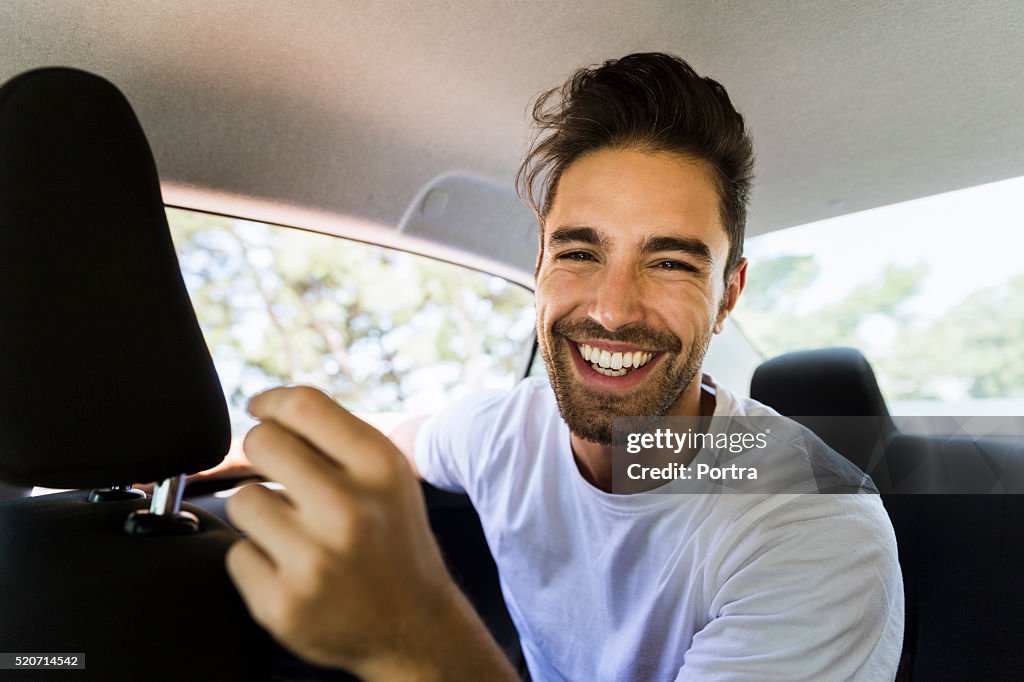 Happy young man in car