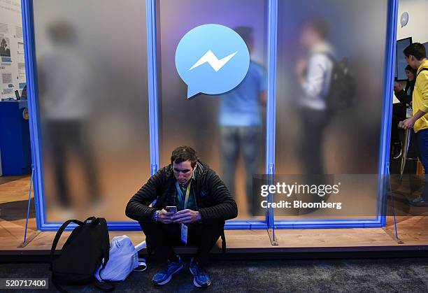 An attendee sits in front of a messenger logo during the Facebook F8 Developers Conference in San Francisco, California, U.S., on Tuesday, April 12,...