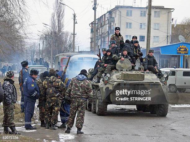 Russian Army armored personnel carrier and special police forces are seen outside a multistorey block of flats where suspected pro-Chechen militants...