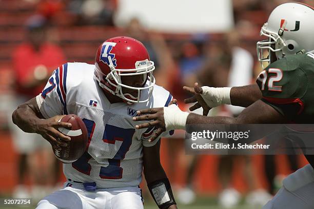 Quarterback Donald Allen of the Louisiana Tech Bulldogs tries to avoid defensive lineman Orien Harris of University of Miami Hurricanes during the...