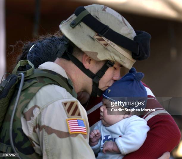 Army Spc. Jerald Duncan kisses his son, Bryce, goodbye during the deployment of the 3rd Infantry Division January 27, 2005 at Fort Stewart, Georgia....