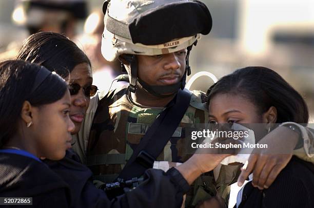 Army Staff Sgt. Scotty Walker hugs his wife Adella and his twin daughters, Sheri and Teri goodbye during the deployment of the 3rd Infantry Division...