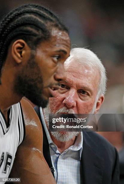 San Antonio Spurs head coach Gregg Popovich talks with Kawhi Leonard of the San Antonio Spurs during a timeout against the Oklahoma City Thunder at...