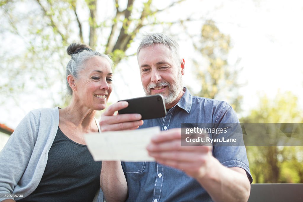 Mature Couple Remote Banking with Phone