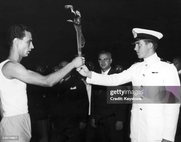 The future King Constantine of Greece hands over the Olympic flame, which will be transported from Greece to Italy on board the Amerigo Vespucci for...