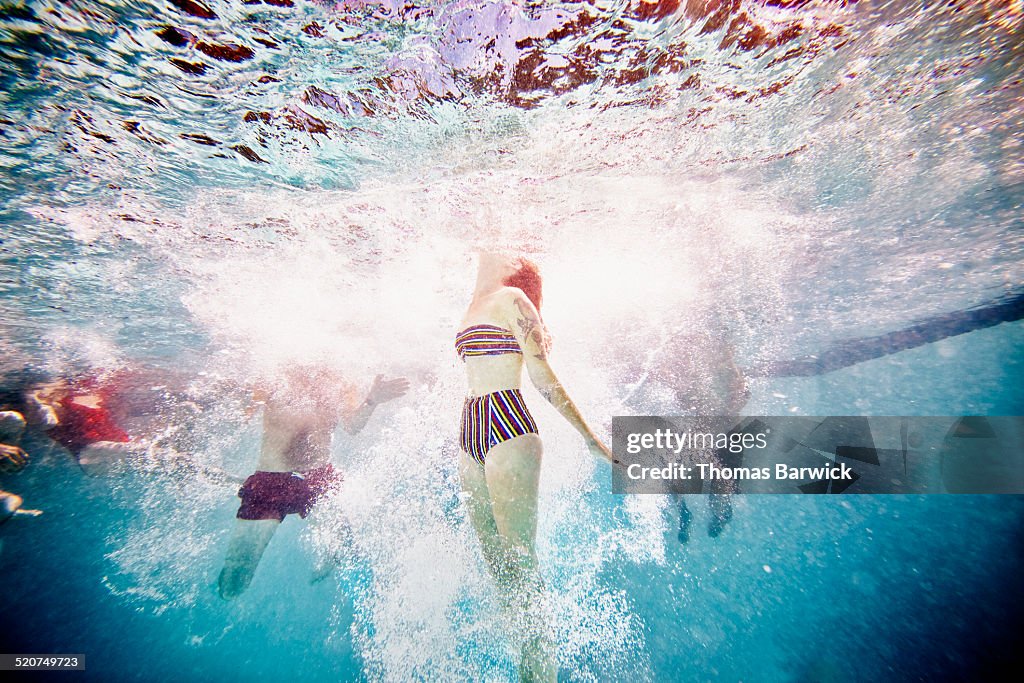 Woman swimming to surface of pool underwater view