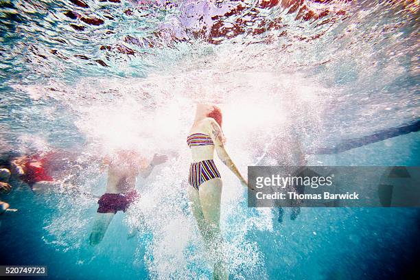Woman swimming to surface of pool underwater view