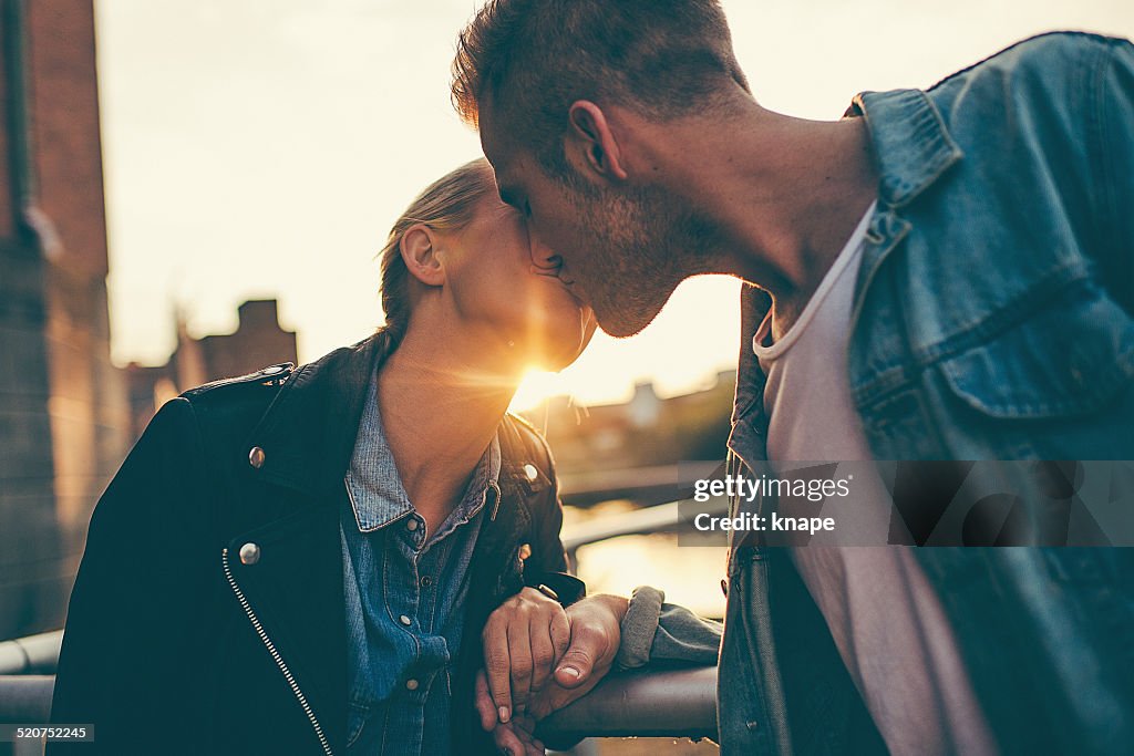 Cute young couple kissing in sunset