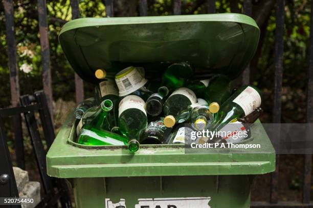 green glass recycling bin full of bottles - glasbak stockfoto's en -beelden