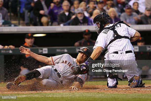 Hunter Pence of the San Francisco Giants is tagged out at home by catcher Nick Hundley of the Colorado Rockies while trying to score on single by...