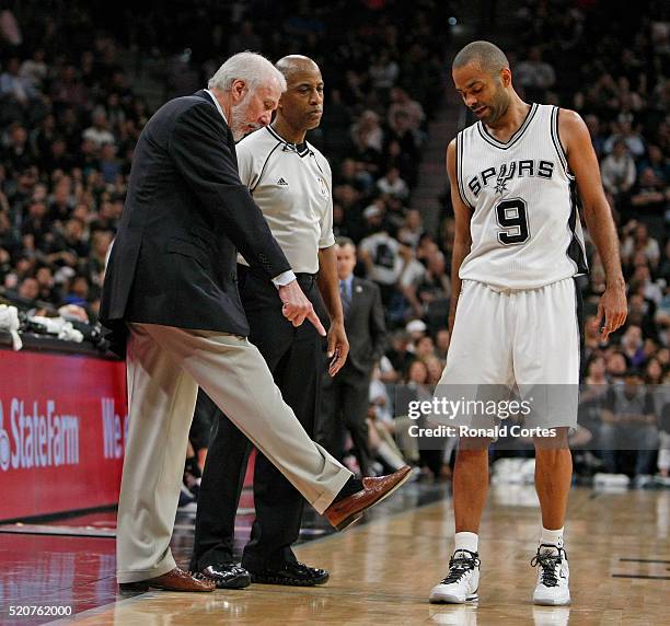 Tony Parker of the San Antonio Spurs listens as head coach Gregg Popovich talks with official Derrick Stafford at AT&T Center on April 12, 2016 in...