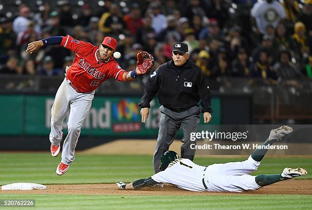 Yaunel Escobar of the Los Angeles Angels of Anaheim leaps to keep the ball from going into left field as Billy Burns of the Oakland Athletics steals...