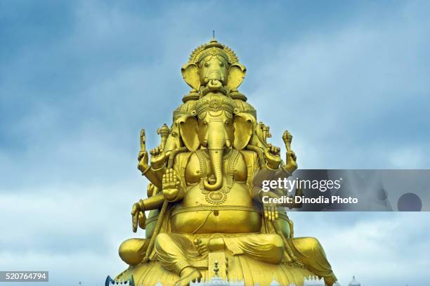 lord ganesh with four heads in golden color, karnataka, india - hindu segenszeichen stock-fotos und bilder