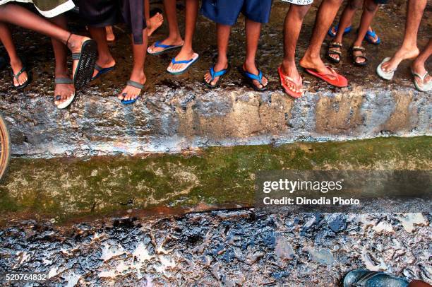 children showing oil soaked feet due to container ship chitra colliding in sea, bombay mumbai, maharashtra, india - dirty feet stock-fotos und bilder