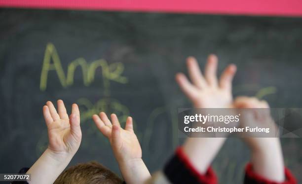 Children wave their hands at a private nursery school January 28, 2005 in Glasgow, Scotland. The average price of pre-school care has increased over...