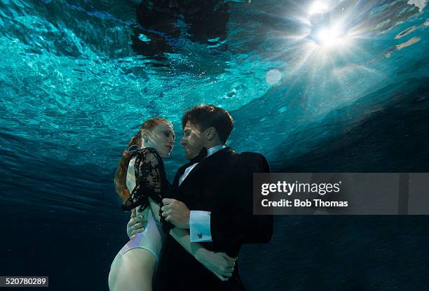 couple underwater - mondlicht stock-fotos und bilder