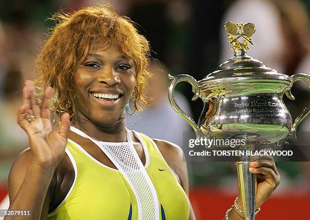 Serena Williams of the US waves as she poses with the winner's trophy following her victory over compatriot Lindsay Davenport in the women's singles...