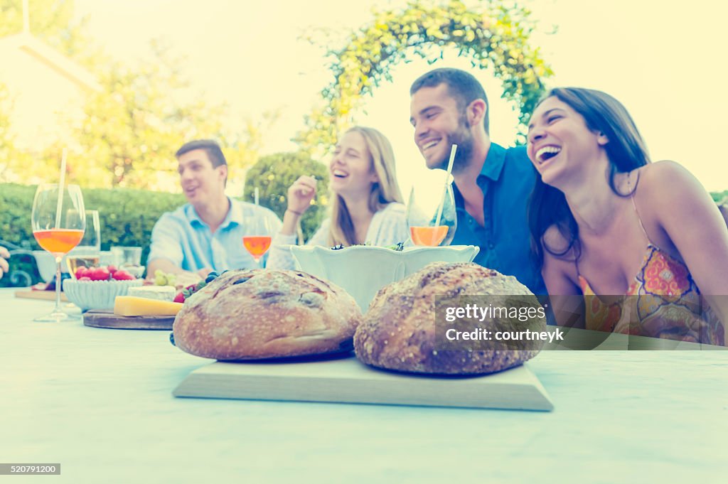 Group of young people eating outdoors.