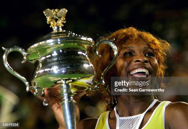 Serena Williams of the USA holds aloft the trophy after winning the Womens Final against Lindsay Davenport of the USA during day thirteen of the...