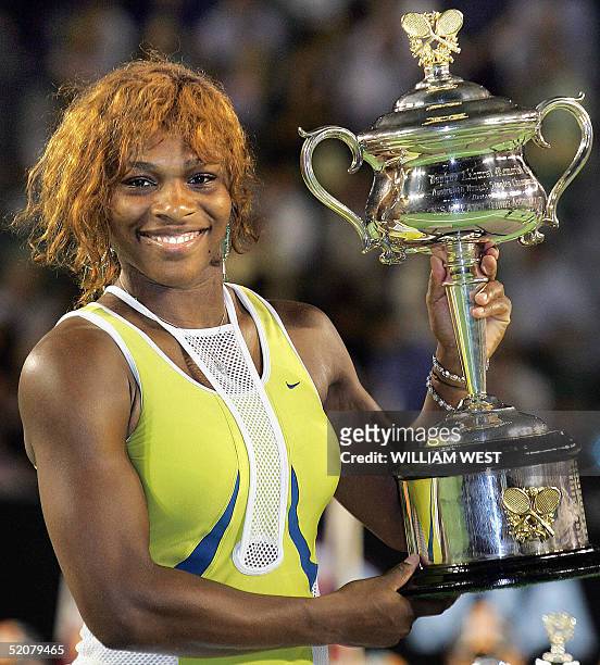 Serena Williams of the US poses with the winner's trophy following her victory over compatriot Lindsay Davenport in their women's singles final at...