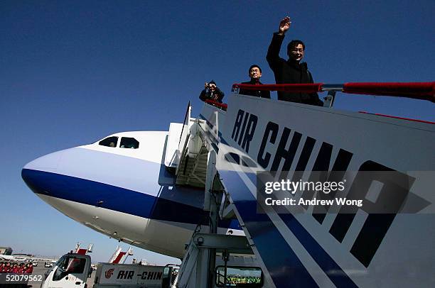Passenger waves as he disembarks the first direct flight from Taipei to Beijing by Taiwan's China Airlines on January 29, 2005 at Beijing's Capital...