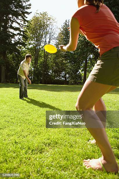 couple playing frisbee - flying disc stock pictures, royalty-free photos & images
