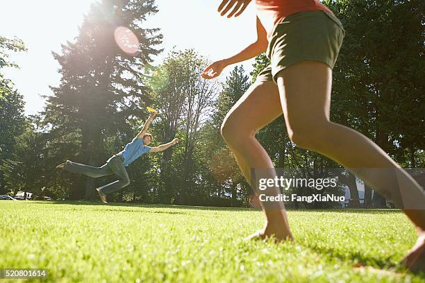 pareja jugando frisbee - frisbee fotografías e imágenes de stock