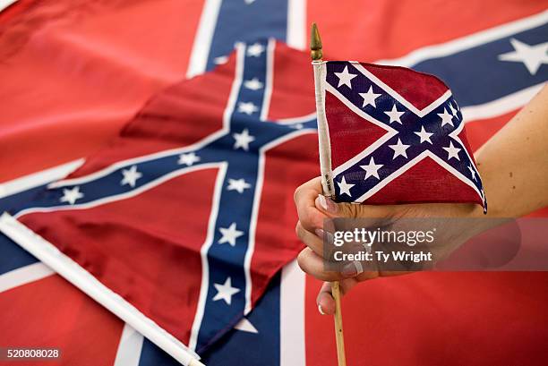 An employee holds up a Confederate flag during the manufacturing process at the Alabama Flag and Banner on April 12, 2016 in Huntsville, Alabama. The...