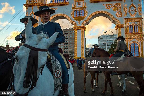 Men wearing traditional attires ride horses in front the main entrance as they enjoy the atmosphere at the Feria de Abril on April 12, 2016 in...