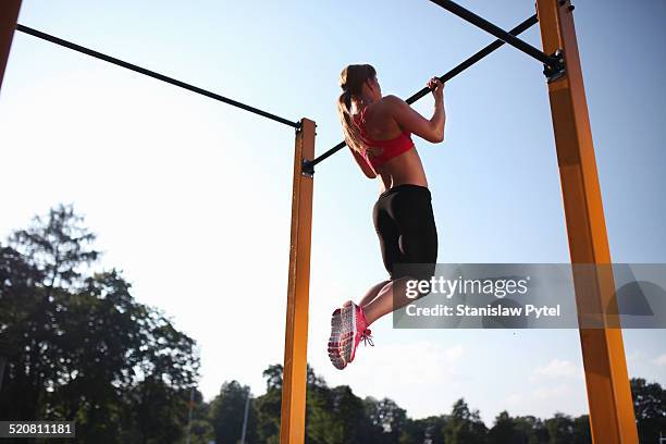 girl training on chin-up bar outdoor - chin ups stockfoto's en -beelden