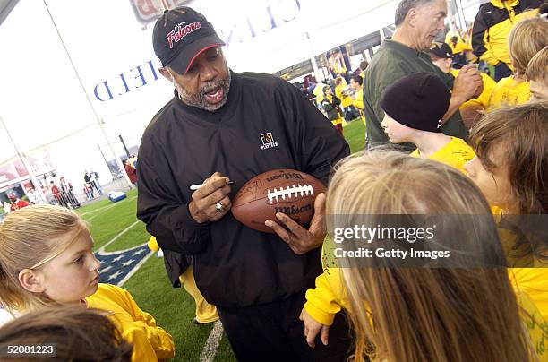 Former NFL player Dewey McClaine signs autographs for kids after a skills clinic at the NFL Experience Stay Cool in School January 29, 2004 in...