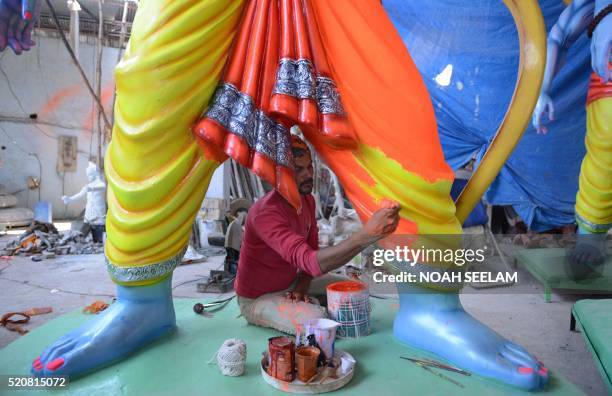 An Indian artist puts the final touches to statues of the Hindu God Lord Ram ahead of the Sri Rama Navami Festival at a workshop in Hyderabad on...