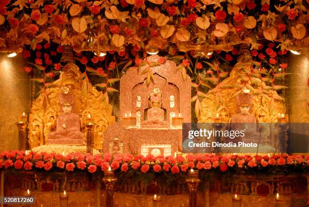 jain god mahavir swami suvrat muni and adeshwar swami decorated with flowers - jaïnisme stockfoto's en -beelden