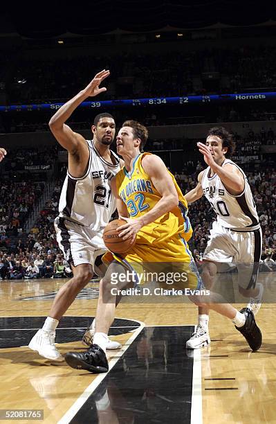 Casey Jacobsen of the New Orleans Hornets drives past Tim Duncan and Manu Ginobili of the San Antonio Spurs on January 29, 2005 at the SBC Center in...