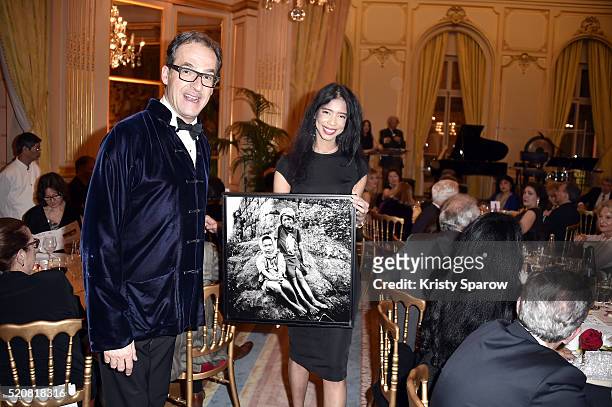 Emmanuel de Brantes presents a photograph with a model by Stephane de Bourgies for auction during 'The Children for Peace' Gala at Cercle Interallie...