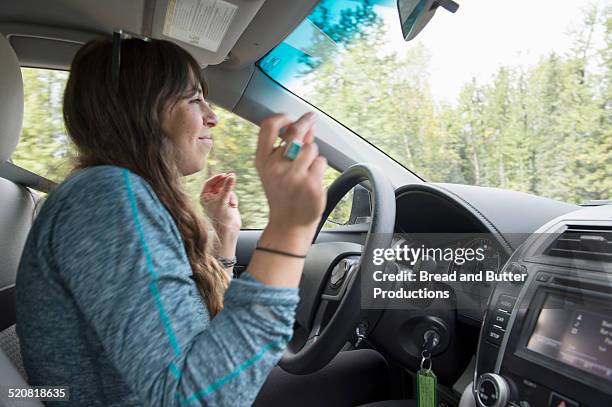 young adult woman driving and dancing - car interior side stock pictures, royalty-free photos & images
