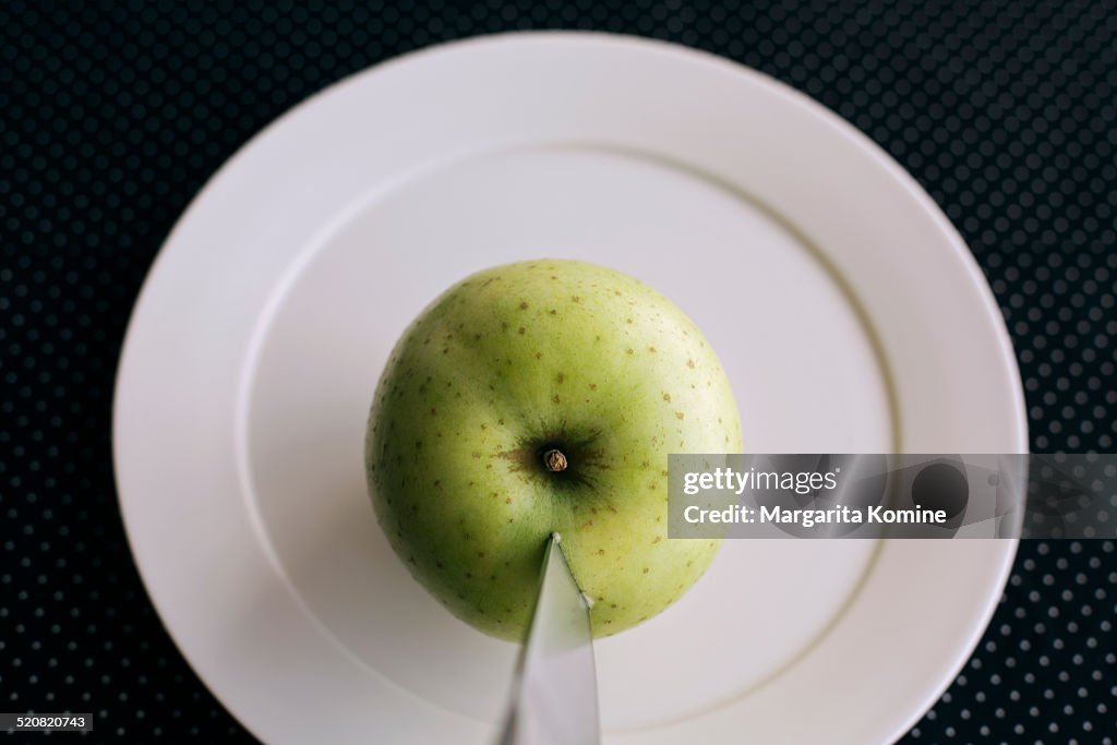 Stabbing a green apple