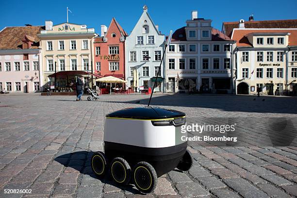Prototype self driving parcel delivery robot, developed by Starship Technologies, travels across a cobblestone square during testing in thje city...
