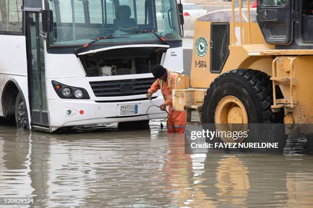 Saudi municipal worker prepares to pump water from a flooded street in Riyadh during heavy rainfall across the Saudi capital, on April 13, 2016. -...