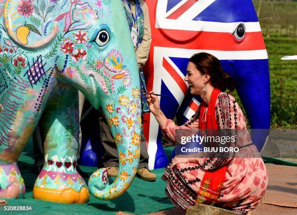 Britain's Catherine Duchess of Cambridge paints an elephant statue at Kaziranga Discovery Park in Panbari village, in Kaziranga, some 250 km from...