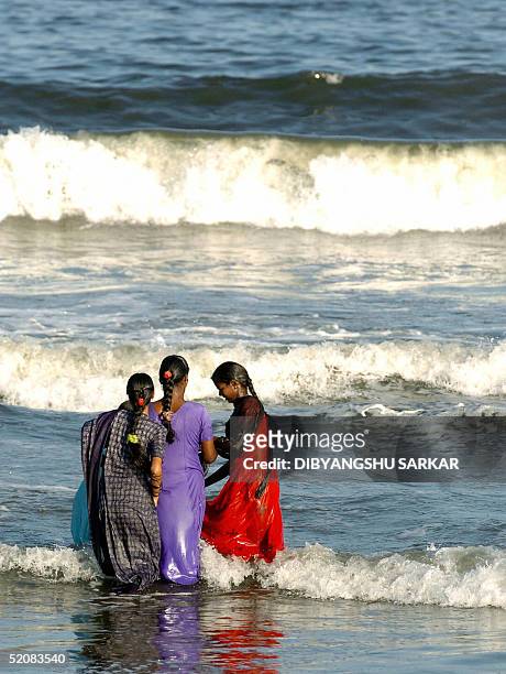 Young Indian women play in the surf off Marina Beach in Madras, 30 January 2005. Just over a month after tidal waves struck the Indian coastline...