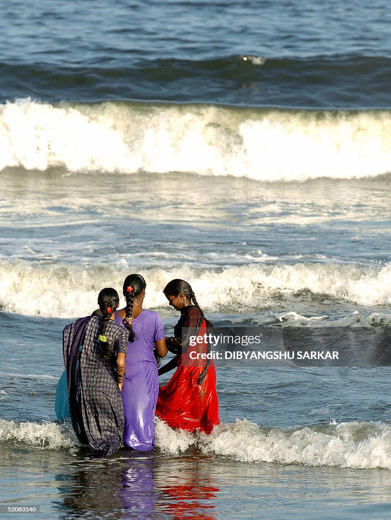 Young Indian women play in the surf off