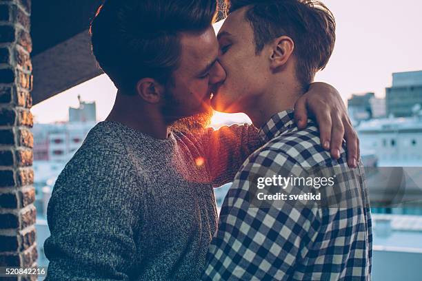 sunset kiss - gay kiss stock pictures, royalty-free photos & images